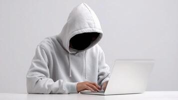 A person wearing a hoodie and using a laptop photo