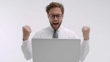 A man in glasses and a shirt is excited while using a laptop photo