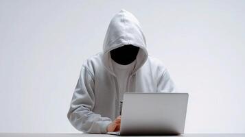 A person in a hoodie sitting at a desk with a laptop photo
