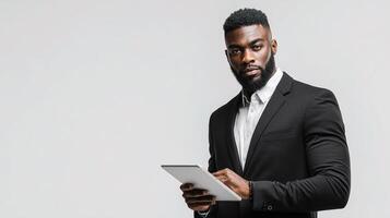 A black man in a suit holding a tablet photo