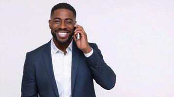 A smiling black man in a suit talking on a cell phone photo