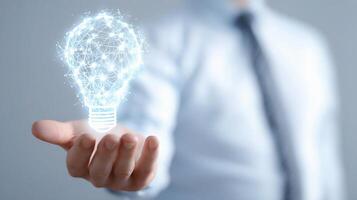 A man in a suit holding a light bulb photo