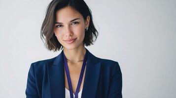 A woman in a business suit with a purple lanyard photo