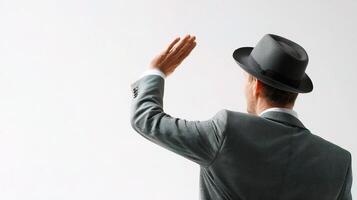 A man in a suit and hat is waving photo