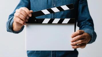 A man holding a clapper board with a blank slate photo