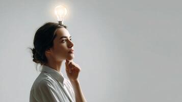 A woman is looking up with a light bulb on her head photo