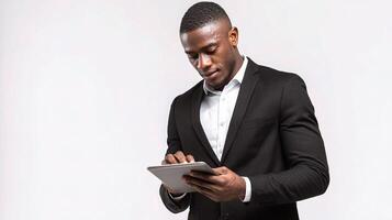 A young african man in a suit is using a tablet photo