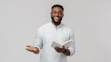 A smiling black man holding a book and smiling photo