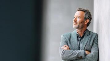 A man leaning against a wall with his arms crossed photo