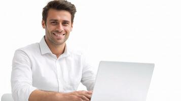 A smiling man sitting at a table with a laptop photo