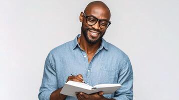 A smiling black man holding a notebook and writing photo