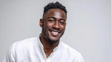A man smiles while wearing a white shirt photo