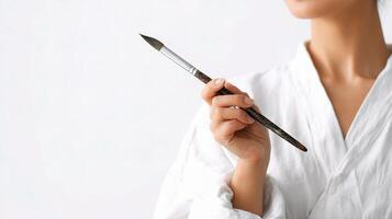 A woman in a white robe holding a brush photo