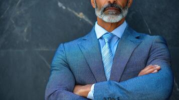 A man with a beard and suit standing in front of a wall photo