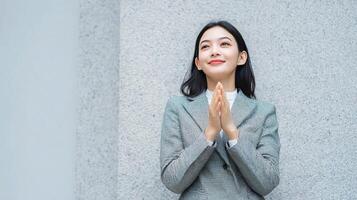 A woman in a business suit is praying photo