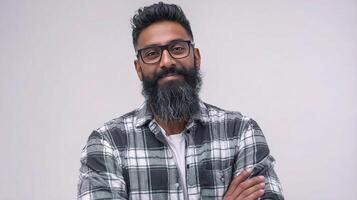 A man with a beard and glasses standing in front of a white background photo