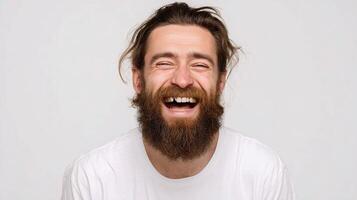 A man with a beard and a white shirt is laughing photo