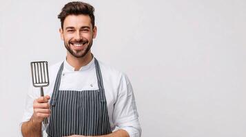 A man in an apron holding a spatula photo