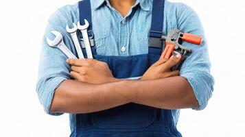 A man in overalls holding tools and a wrench photo