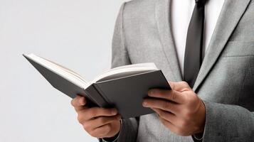 A man in a suit is holding an open book photo