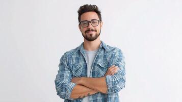 Portrait of a handsome young man with glasses and a plaid shirt standing with his arms crossed photo