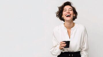 A woman is laughing while holding a cup of coffee photo