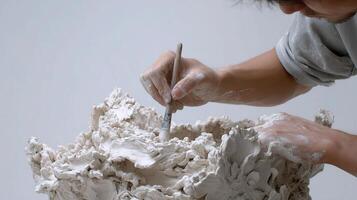 A man is making a sculpture out of clay photo