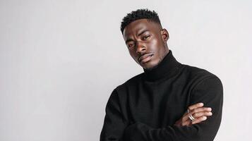 A man in a black turtle neck sweater standing with his arms crossed photo