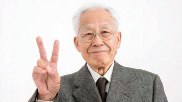 An old man in a suit and tie making the peace sign photo