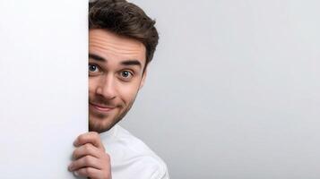 A man peeking out from behind a white wall photo