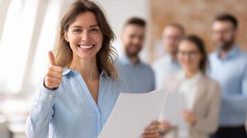 A woman holding a piece of paper and giving the thumbs up photo