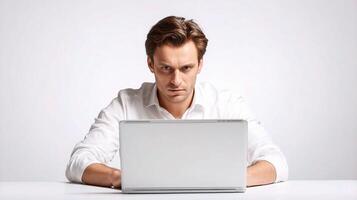 A man sitting at a desk with a laptop photo