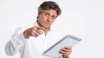 A man holding a notebook and pointing at something photo