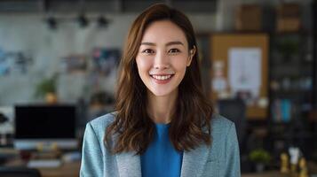 A woman in a blue shirt and blazer is smiling photo