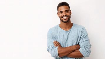 A man is smiling and standing in front of a white wall photo