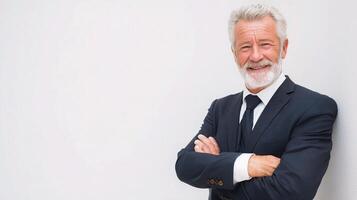 A man with a white beard and a suit standing in front of a white wall photo