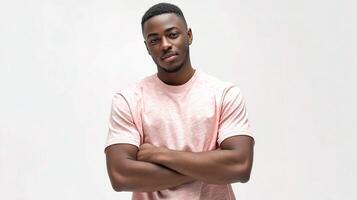A young man in a pink shirt standing with his arms crossed photo