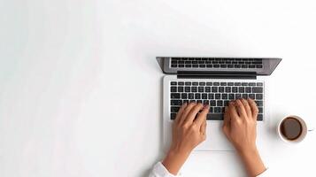 A person typing on a laptop with a cup of coffee photo