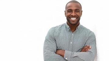A smiling black man standing against a white wall photo