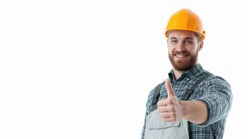 A man in a hard hat and overalls is giving the thumbs up photo