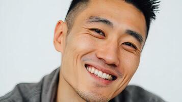 A man smiles while wearing a gray shirt photo