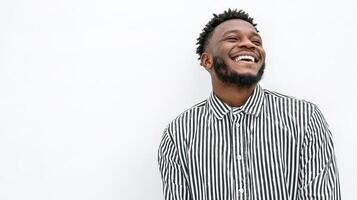 A man with a beard and a striped shirt is smiling photo