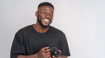 A man with a camera smiling and holding it photo