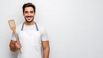 A man in an apron holding a wooden spatula photo