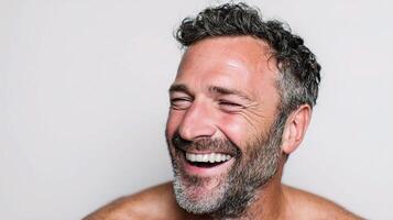 A man with a beard and no shirt is laughing photo