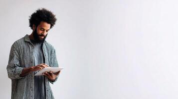 A man with a beard and a shirt is holding a tablet photo