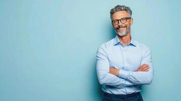 A man with glasses and a beard standing in front of a blue wall photo
