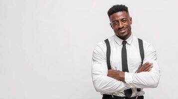 A man in a white shirt and black tie standing with his arms crossed photo