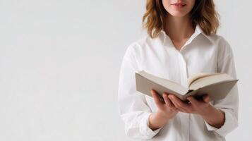 A woman in a white shirt is holding an open book photo