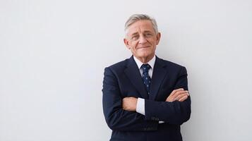 Portrait of a mature businessman standing with his arms crossed against a white background photo